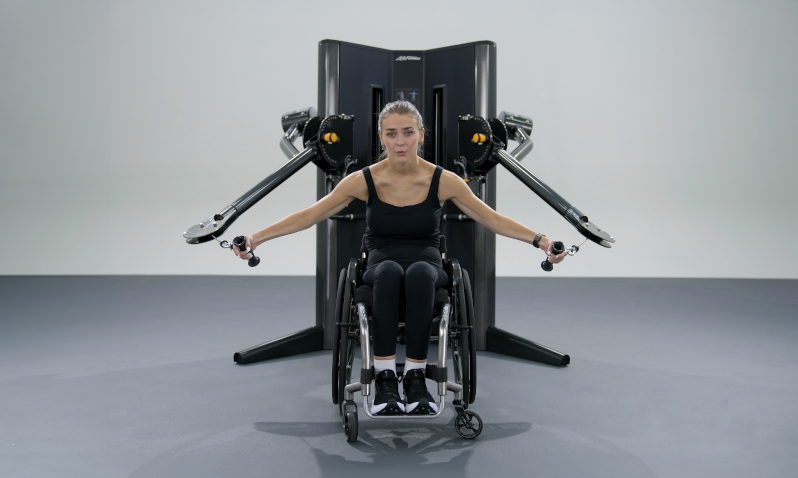 woman in a wheelchair works out with the new Life Fitness cable machine