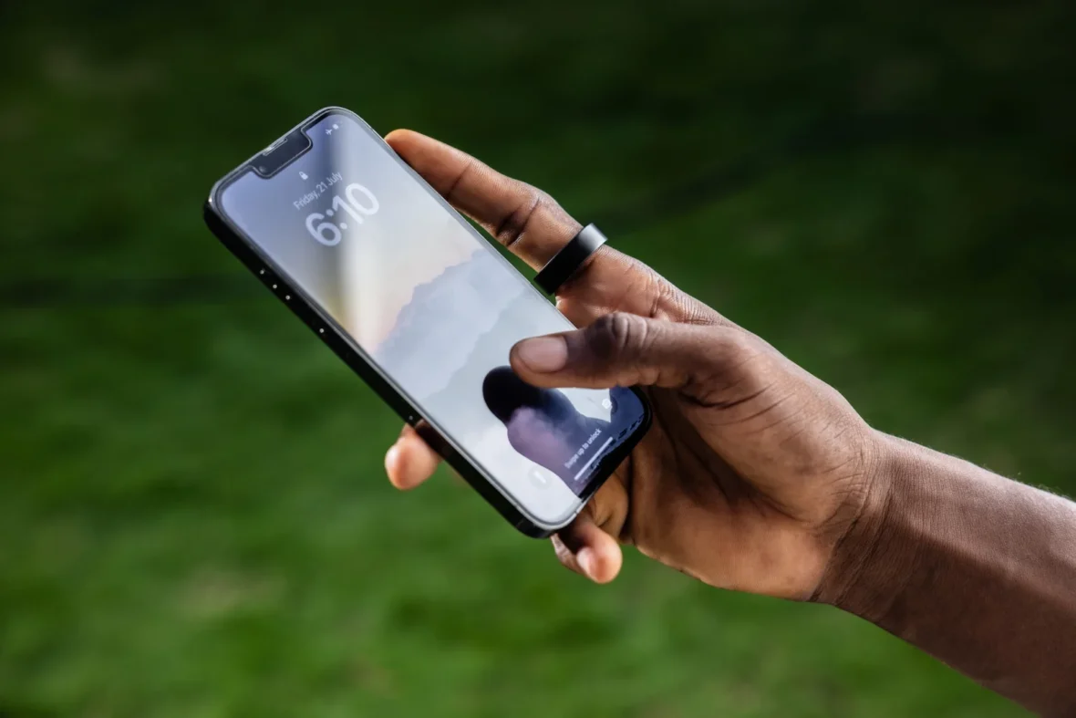 man wearing an Ultrahuman ring uses his smartphone