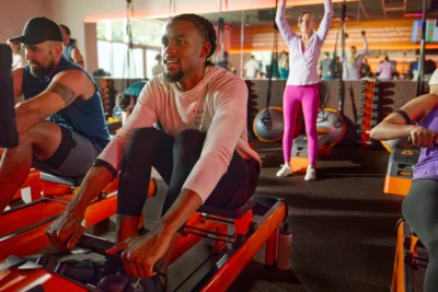 man on a rower inside an Orangetheory studio