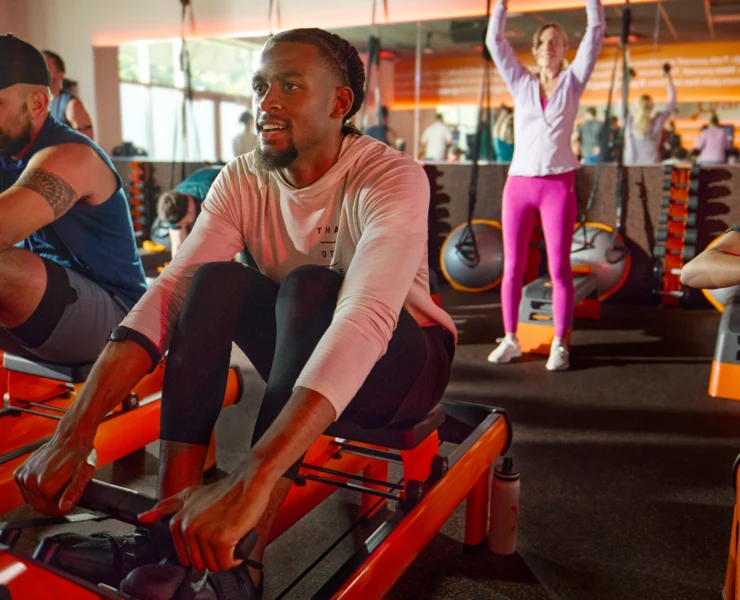 man on a rower inside an Orangetheory studio