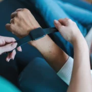 woman places a wearable smartwatch on someone's wrist