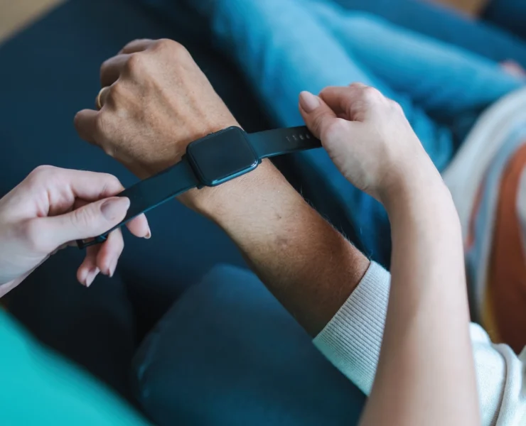 woman places a wearable smartwatch on someone's wrist