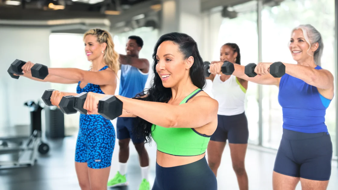 people lift weights inside a Zumba class