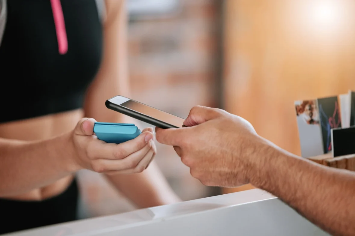 man uses phone to scan into a gym