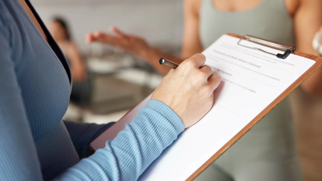 woman signs up for a membership using a clipboard