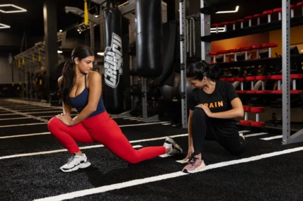 woman works out with a trainer at a Crunch Fitness