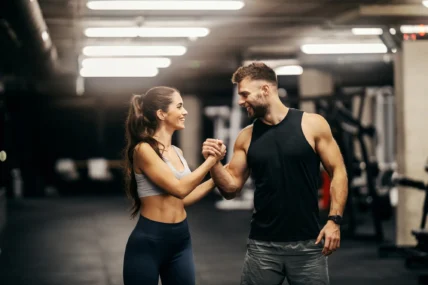 man and woman congratulate each other at the gym