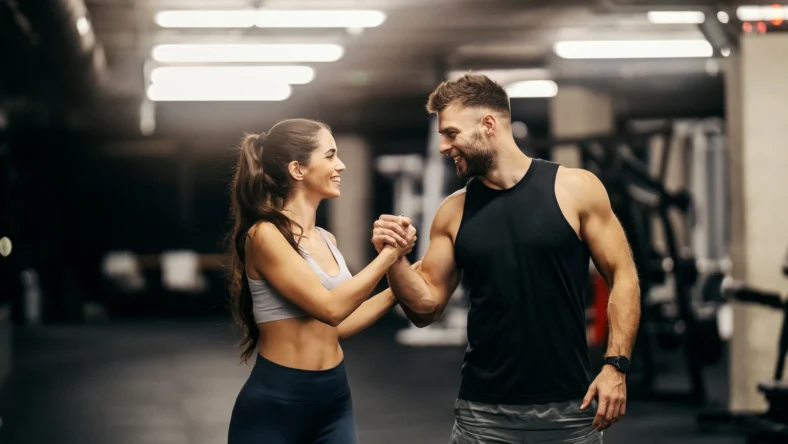 man and woman congratulate each other at the gym
