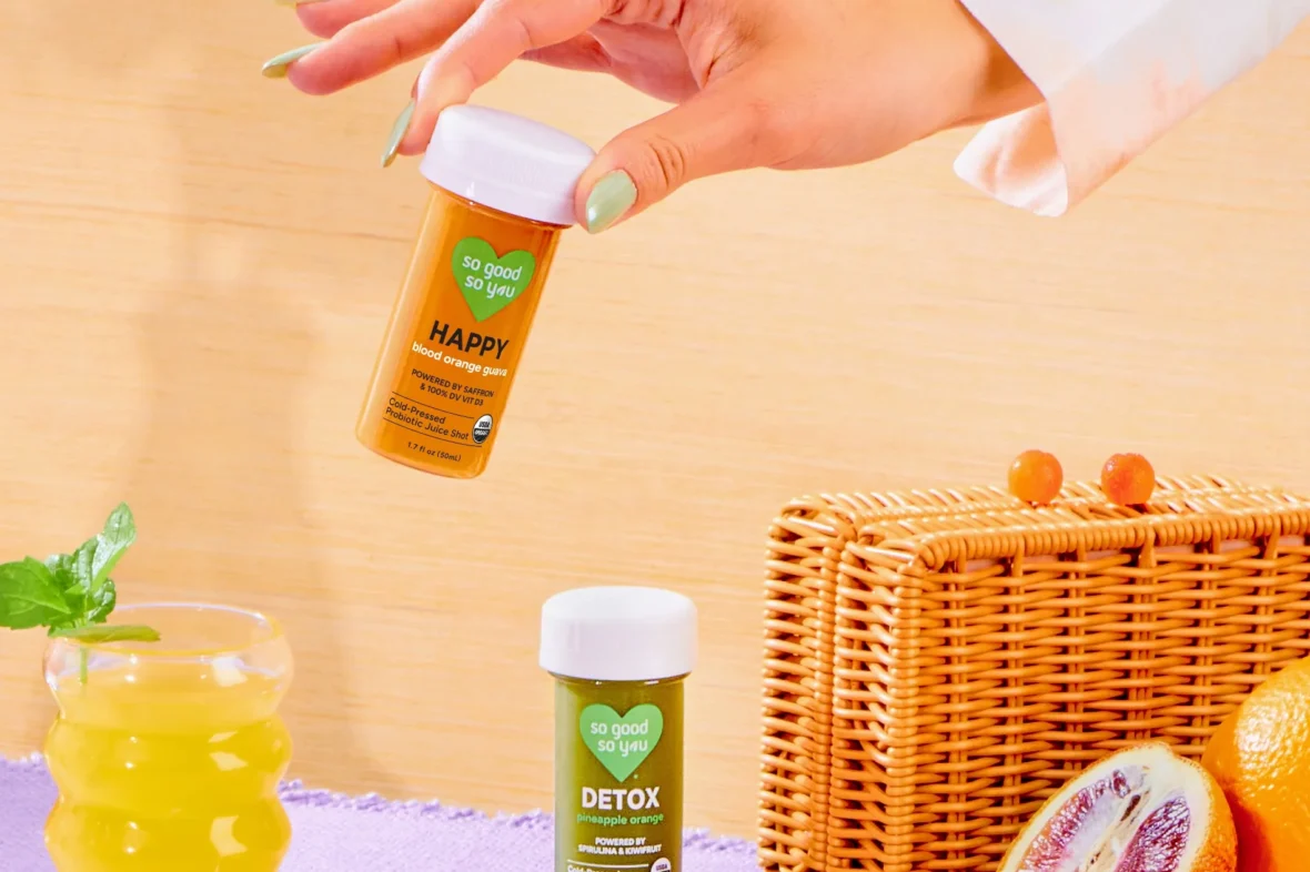 A woman's hand holding a container of So Good So You.