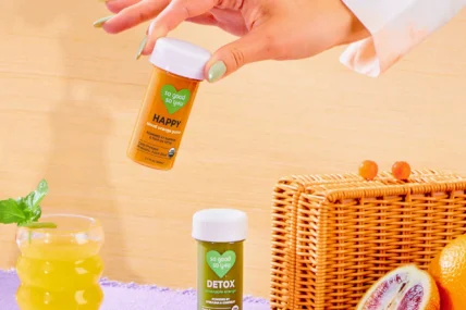 A woman's hand holding a container of So Good So You.