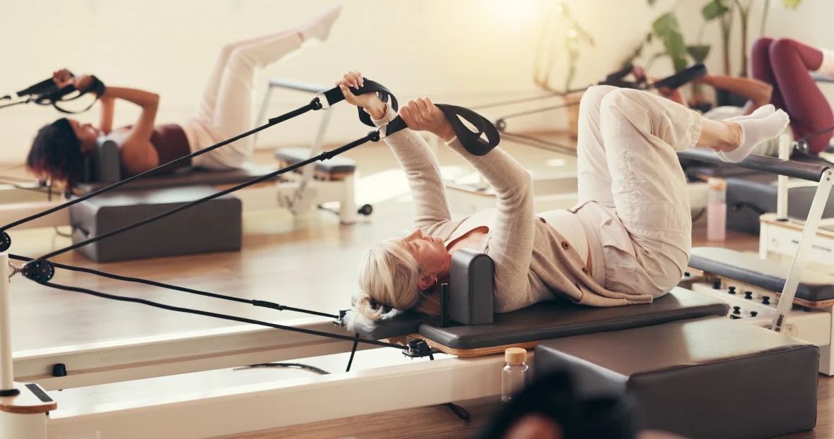 women work out on Pilates reformers