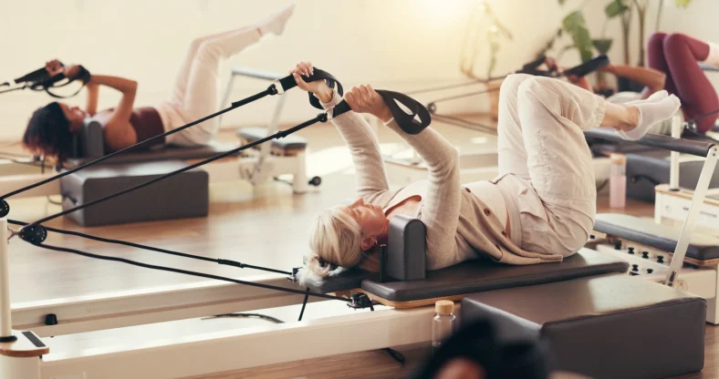 women work out on Pilates reformers