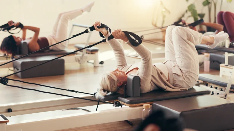 women work out on Pilates reformers