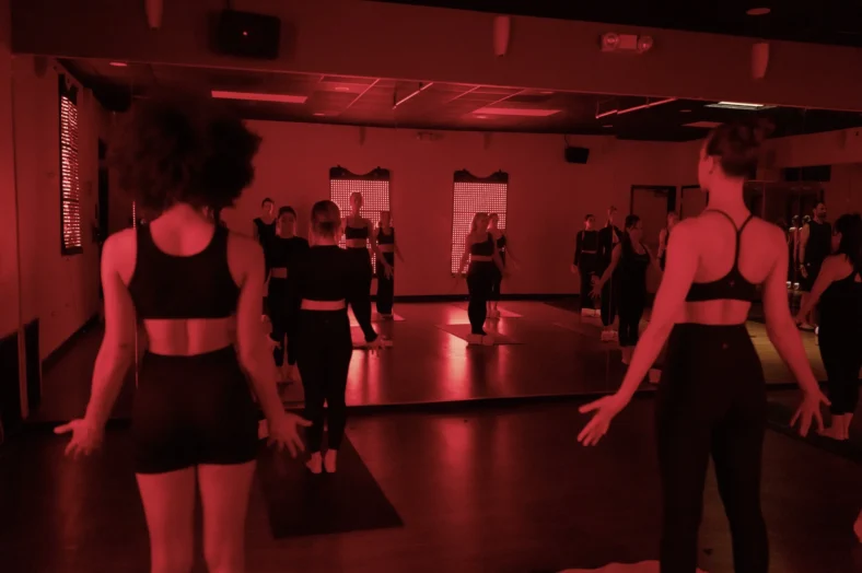 women do yoga inside a red light room