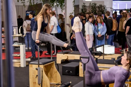 women on Pilates machines at a fitness trade show