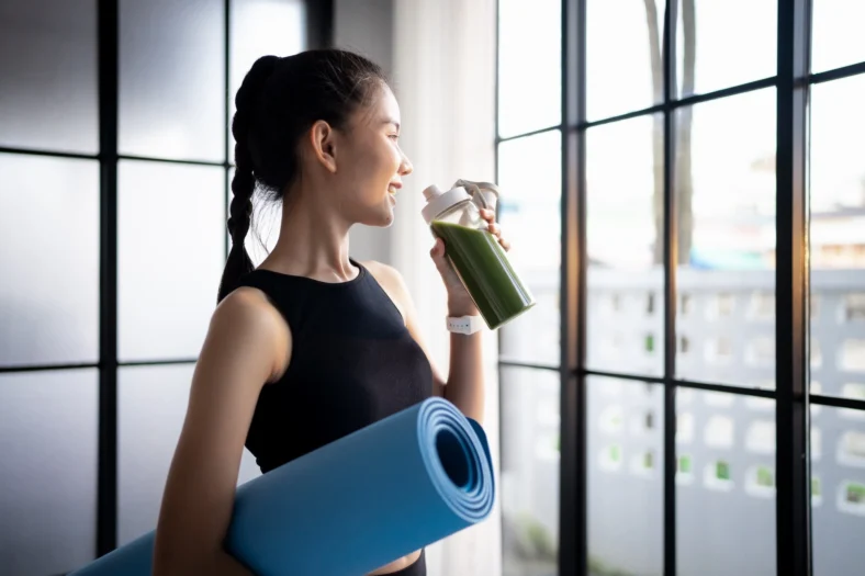woman drinks a green shake