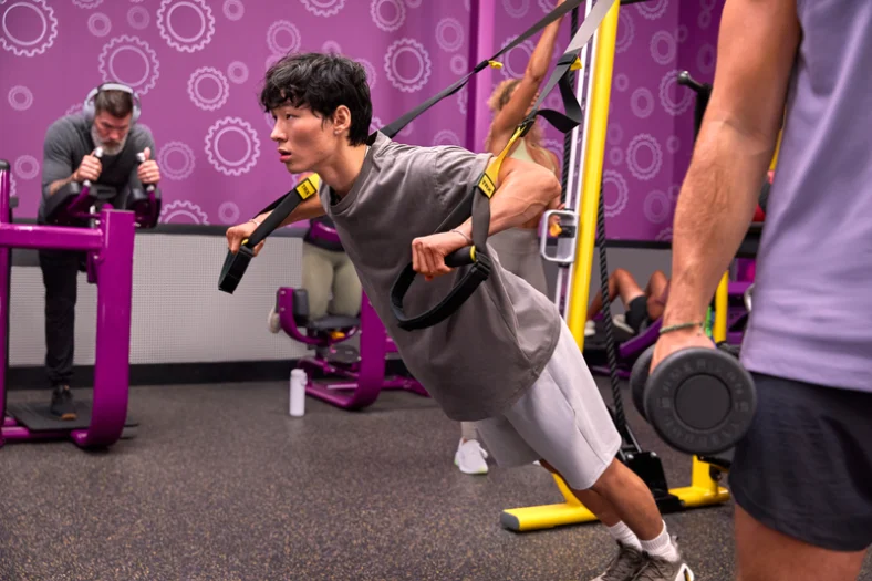 man uses TRX straps at a Planet Fitness