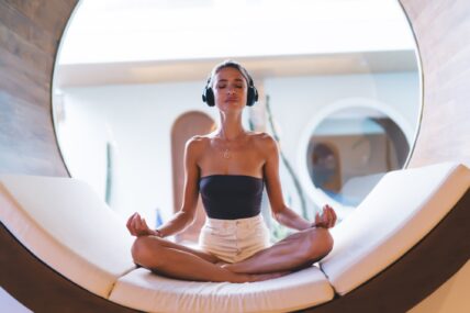 woman in headphones lounges on a circular bed