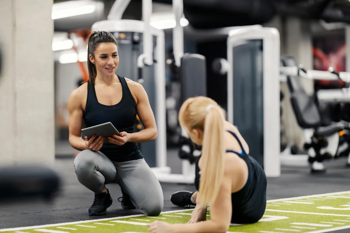 personal trainer helps a client
