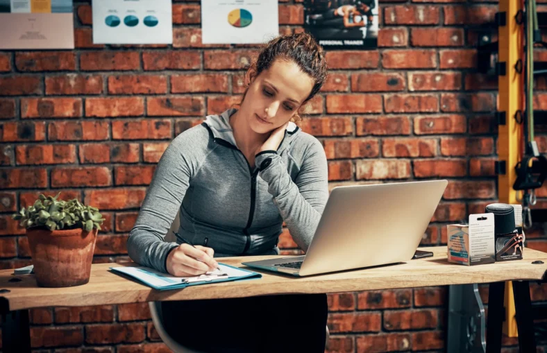 female personal trainer sits at a desk