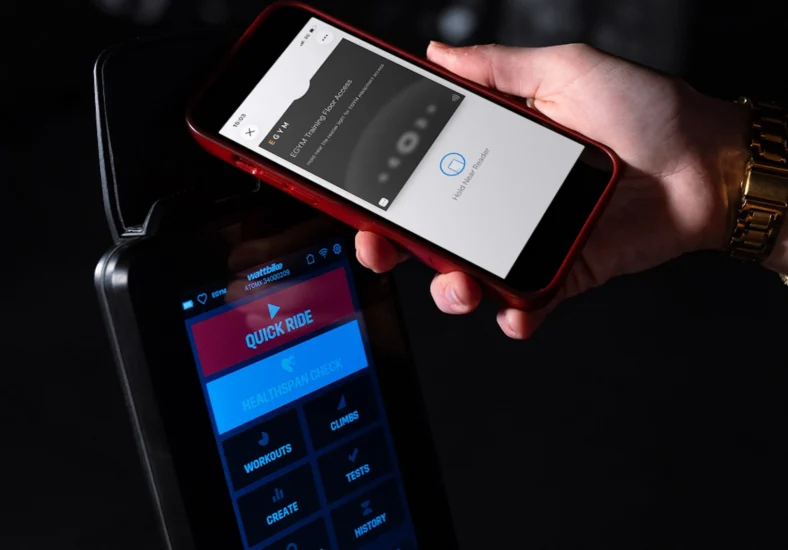 EGYM app on a phone next to Wattbike equipment