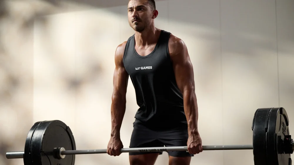 man lifts a barbell in a Life Time shirt