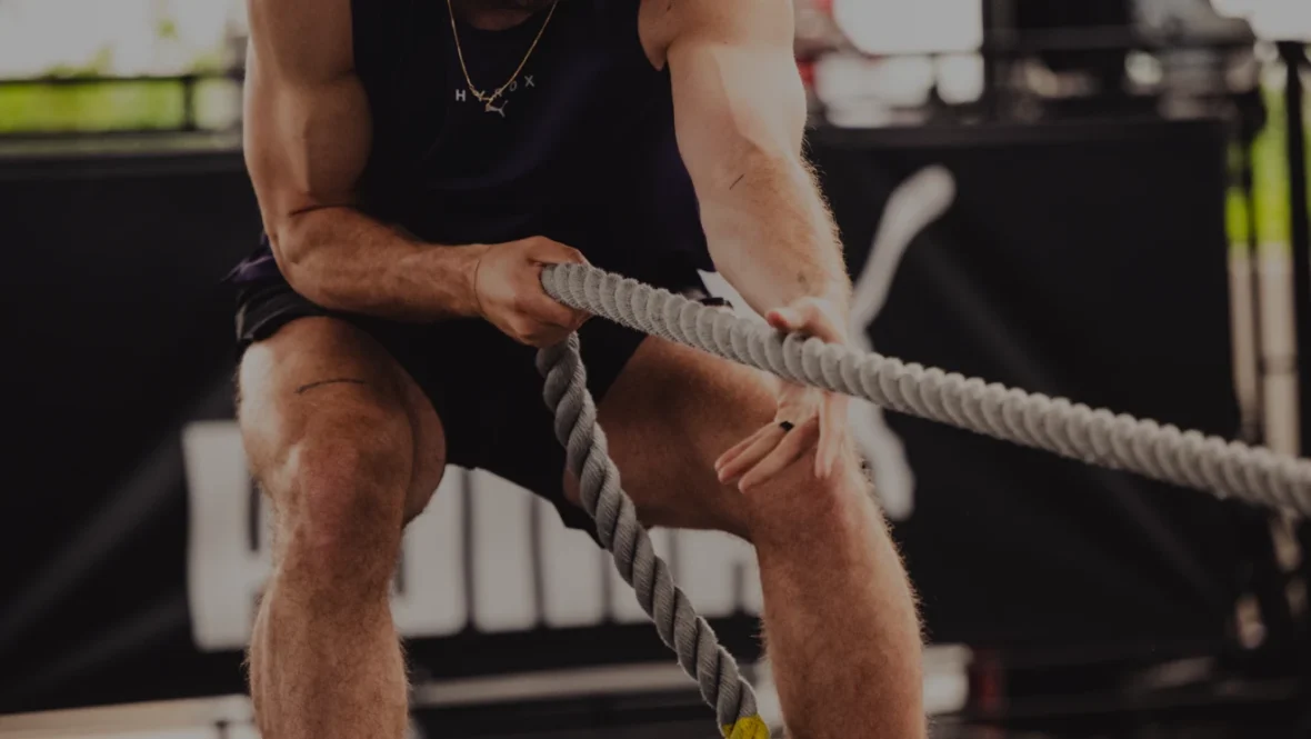 man pulls a rope in a Hyrox competition