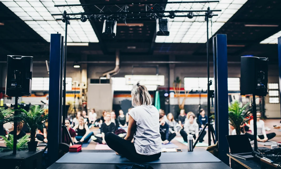 woman teaches on stage at a yoga event